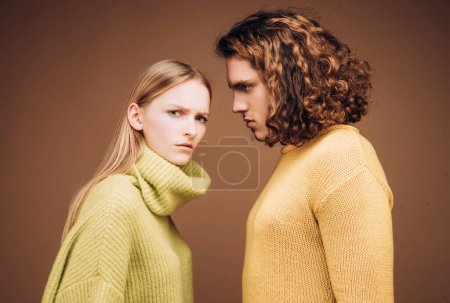 Téléchargez les photos : Jeune couple de mode sur fond beige en studio. Couple d'homme aux cheveux bouclés et femme blonde dans le salon de coiffure. Coiffeur ou salon de coiffure concept - en image libre de droit