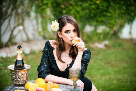 Photo for Beautiful sexy girl in garden eating tropical fruit, summer vacation - Royalty Free Image
