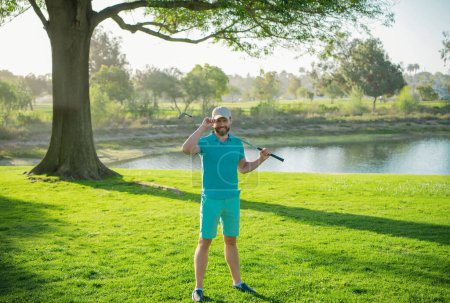 Photo for Male golf player on professional golf course. Golfer man with golf club taking a shot - Royalty Free Image