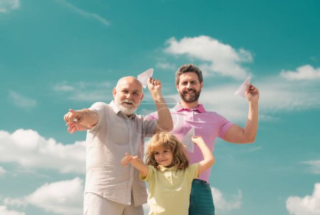Trois générations différentes âges grand-père père et enfant fils jouer avec jouet avion à l'extérieur. Aventure familiale, imagination, innovation et inspiration