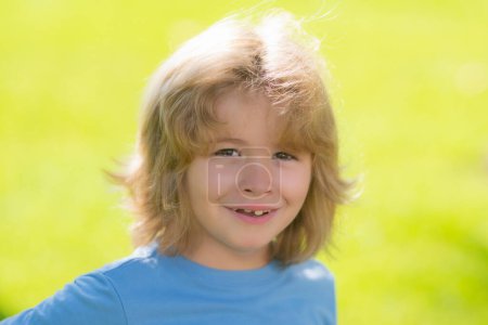 Photo for Cute funny blonde little child close up portrait on green grass background. Outdoor closeup portrait of funny kids face. Summer kid outdoor portrait. Close up face of cute child - Royalty Free Image