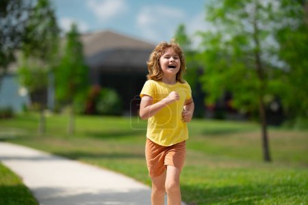 Téléchargez les photos : Jeune enfant sportif courir le jogging et l'entraînement en plein air. Course et sport sain pour les enfants. Enfant qui court sur les enfants de la rue fitness. Entraînement en plein air, jogging matinal. Exercice de course - en image libre de droit