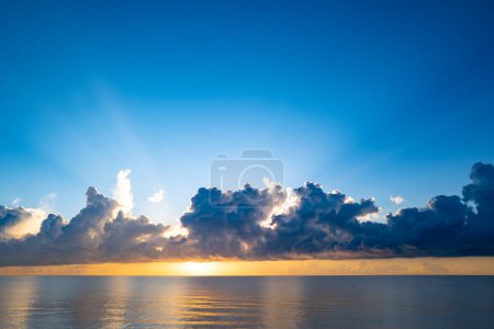 Sunset on tropical beach sea ocean with sunrise clouds. Banner for travel vacation. Scenery sky and reflection rays in water. Panorama on sea at sunset. Beautiful seascape