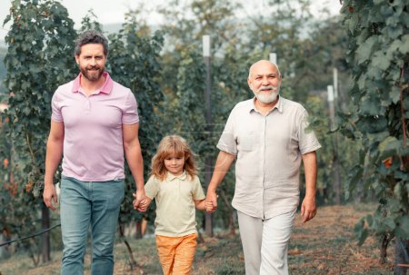 Téléchargez les photos : Famille de génération masculine avec trois générations différentes âges. Grand-père père et fils marchant jardin de printemps - en image libre de droit
