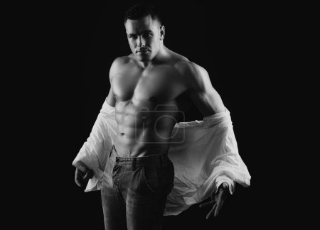 Photo for Man take off shirt. Mens fashion concept. Muscular shirtless manked man model showing six pack abs. Gay sexy model. Shirtless athletic hot naked guy with abs - Royalty Free Image