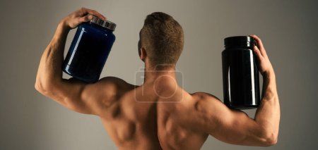 Foto de Dieta vitamínica y nutrición deportiva. El hombre fuerte sostiene botellas de suplemento. Hombre muscular con suplementos proteicos. Culturismo deporte y fitness. Dieta deportiva. Apoyo al metabolismo - Imagen libre de derechos