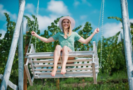 Foto de Retrato al aire libre de una chica feliz sonriente. Sensual mujer balanceándose en el columpio en la naturaleza de verano, joven chica sexy relajarse en el parque de primavera al aire libre - Imagen libre de derechos