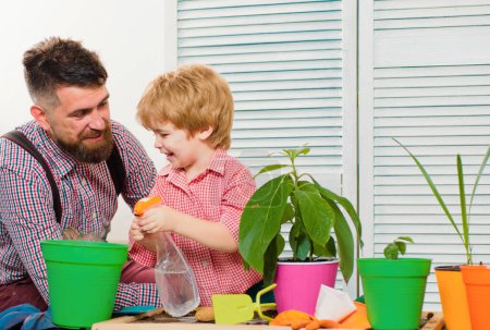 Photo for Child son with father growing plant in pot. Family holiday and togetherness. Little cute boy helps his parent. Happy family planting sprout in a plant pot - Royalty Free Image