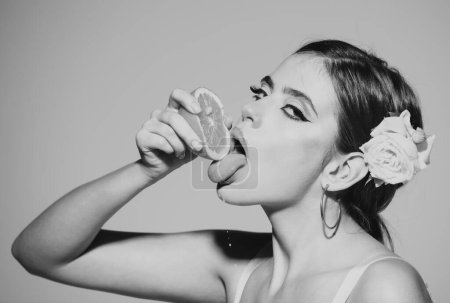 Photo for Closeup face of beautiful amazing woman eating orange, lick with tongue natural orange juice, isolated on white gray background - Royalty Free Image