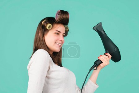 Téléchargez les photos : Femme avec sèche-cheveux isolé en studio. Belle fille avec cheveux raides sèche-cheveux avec sèche-cheveux professionnel - en image libre de droit