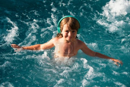 Téléchargez les photos : Joyeux jeune garçon enfant s'amusant dans l'eau et profite des vacances d'été dans la piscine. Joyeux concept d'enfance insouciante. Vacances d'été pour enfants - en image libre de droit