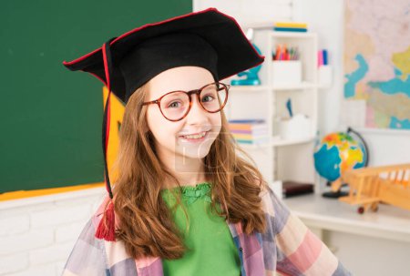 Photo for Cute girl in elementary school in university cap - Royalty Free Image