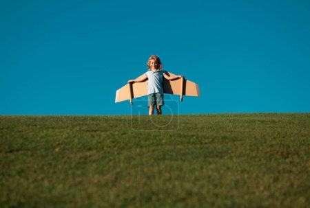 Foto de Niño jugando con la mochila de juguete. Niño piloto astronauta o astronauta sueña con volar. Aviador volando con alas de cartón - Imagen libre de derechos