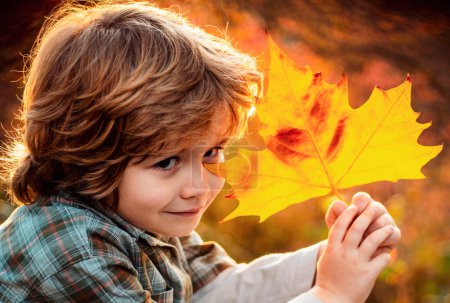 Foto de Retrato infantil de otoño de cerca. Niño lindo en el parque de otoño - Imagen libre de derechos