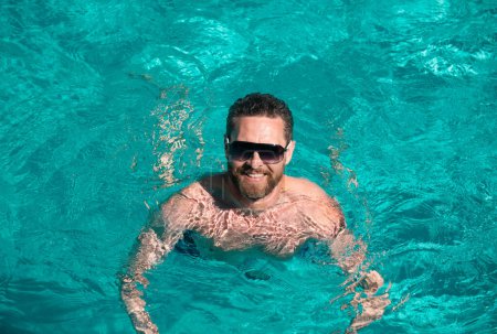 Foto de Vacaciones de verano. Un hombre guapo en la piscina. Fiesta en la piscina. Centro de verano. Hombre en fin de semana de verano - Imagen libre de derechos