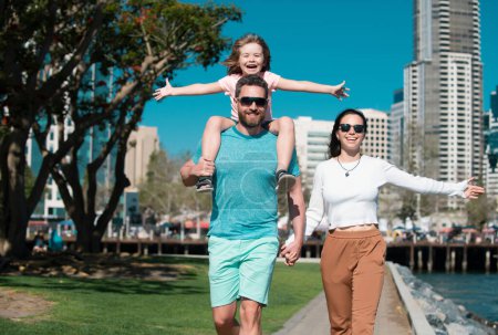 Photo for Family in the city. Family walking in urban park. Little boy kid with father carrying him on shoulders - Royalty Free Image