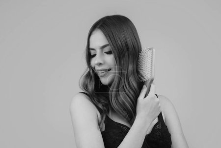 Foto de Mujer sonriente cepillando el cabello con peine. Hermosa chica peinando pelo largo con cepillo - Imagen libre de derechos