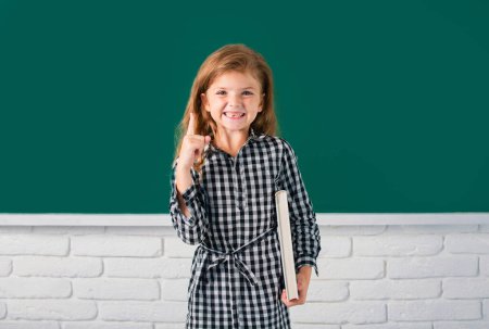 Foto de Chica de la escuela con el dedo que señala estudiar matemáticas en la lección en el aula de la escuela primaria - Imagen libre de derechos