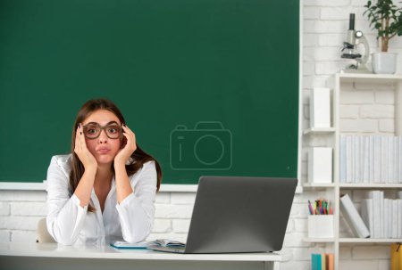 Photo for Portrait of a young sad serious and concerned female student studying in school classroom - Royalty Free Image