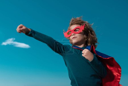 Foto de El niño hace de superhéroe. Niño en el fondo en el cielo azul - Imagen libre de derechos