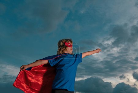 Photo for Superhero kid against blue sky background. Copy space - Royalty Free Image