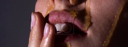 Foto de Goteo de miel en la boca. Labios tiernos sexy - Imagen libre de derechos