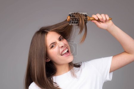 Téléchargez les photos : Girl combing hair with comb. Beautiful young woman holding hair comb. Female model hold comb near face. Woman portrait with comb - en image libre de droit