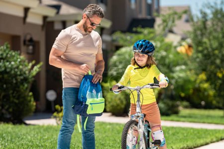 Photo for Fathers day. Father and son riding a bike on the road at the fathers day. Concept of friendly family. Parents and children friends. Father and son riding a bike outdoor on summer day. Child first bike - Royalty Free Image
