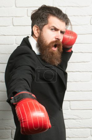 Foto de Hombre en traje con guantes de boxeo en posición de guardia, conflicto y concepto de lucha. Hombre de negocios con guantes de boxeo perforando - Imagen libre de derechos