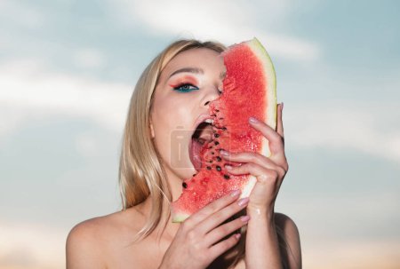 Photo for Sexy summer tropical fruit. Sexy mouth bite watermelons. Sensual young woman lick watermelon with sexy tongue. Young woman holding slice of watermelon against half part of face - Royalty Free Image