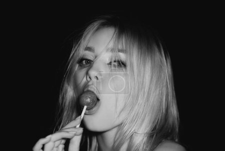 Photo for Desire. Sexy woman face. Sensual glamorous attractive lady licking yummy sugary lollypop with red lips. Girl sucks lollipop. Flirting sexy female pop art style - Royalty Free Image