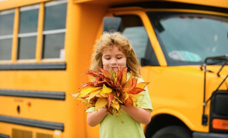 Foto de De vuelta a la escuela en septiembre. Niño de otoño cerca del autobús escolar. Follaje de otoño. Colegial escolar en otoño otoño escuela parque - Imagen libre de derechos