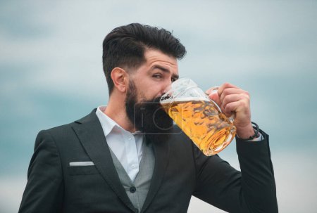 Foto de Perfil retrato de hombre barbudo elegante bebiendo cerveza. Cerveza feliz sosteniendo vaso con cerveza - Imagen libre de derechos