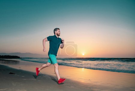 Téléchargez les photos : Portrait d'un homme actif d'âge moyen faisant du jogging en courant dehors par la mer - en image libre de droit