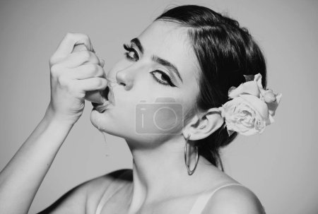 Photo for Close up portrait of sexy woman with stylish makeup on beautiful face squeezing juice from fresh orange, lick orange juice on a gray background - Royalty Free Image
