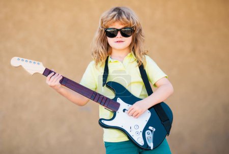 Foto de Child musician guitarist playing electric guitar. Music kids - Imagen libre de derechos