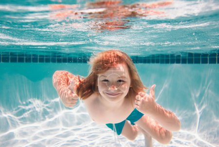 Téléchargez les photos : Enfants jouant dans la piscine. Un jeune garçon nage et plonge sous l'eau. Portrait sous l'eau dans piscine. Enfant garçon plongeant dans une piscine - en image libre de droit