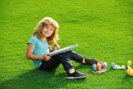 Photo for Kids painting in spring nature. Child boy drawing in summer park, painting art. Little artist painter draw pictures outdoor - Royalty Free Image