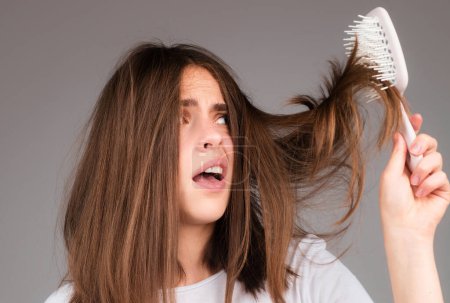 Téléchargez les photos : Femme perte de cheveux avec un peigne et les cheveux problème. Perte de cheveux femmes stressées et problèmes chauves - en image libre de droit