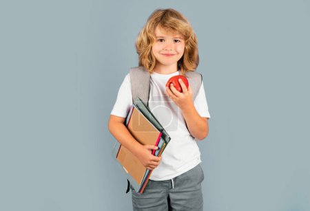 Téléchargez les photos : Écolier en uniforme scolaire avec sac à dos. Adolescent sur fond isolé - en image libre de droit