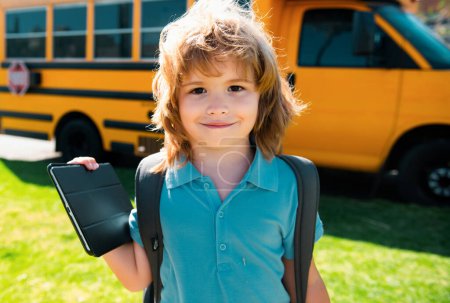 Foto de Retrato de un pequeño alumno feliz al aire libre en el autobús escolar - Imagen libre de derechos