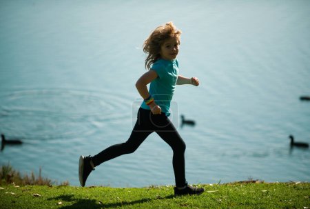 Photo for Kids running outdoors. Run and healthy sport for children. Child running on summer field near lake, kids fitness. Running training outdoor, morning jogging. Children athletes - Royalty Free Image