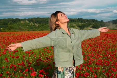Photo for Beautiful young woman in poppy field. Young woman outdoor in poppy field on poppies background. Girl in the field of spring blossom flowering meadow - Royalty Free Image