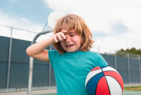 Photo for Boy cries of resentment and grief. Little boy alone, lonely with ball. Loneliness kids. Sad child boy portrait - Royalty Free Image