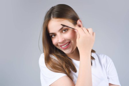 Foto de Eyebrow makeup. Beauty model shaping brows with brow pencil closeup. Womans eyebrows with eyebrow brush. Natural make up. Modeling brows. Comb eyebrows - Imagen libre de derechos