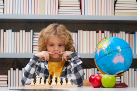 Photo for Child play chess at school. Child think about chess game. Intelligent, smart and clever school kid pupil. Games for brain intelligence concept - Royalty Free Image