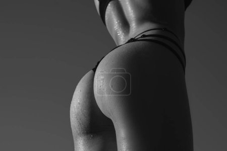 Téléchargez les photos : Beautiful woman body. Female back and buttocks. Sexy female ass in black panties. Woman ass in underwear with sexy ass posing. Firm buttocks in bikini underwear - en image libre de droit