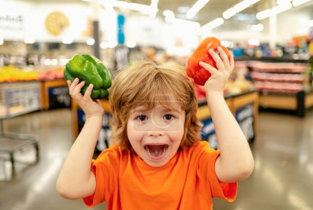 Foto de Lindo niño en una tienda de alimentos o un supermercado eligiendo zanahorias orgánicas frescas. Estilo de vida saludable para familias jóvenes con niños
. - Imagen libre de derechos