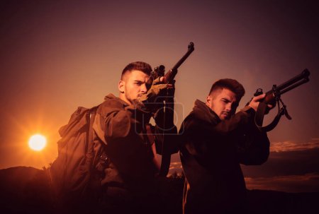 Foto de Silueta del cazador. Rifle Hunter Silhouetted en Beautiful Sunset. Caza en Rusia. La caza es la práctica de matar o atrapar animales. Rastrear - Imagen libre de derechos