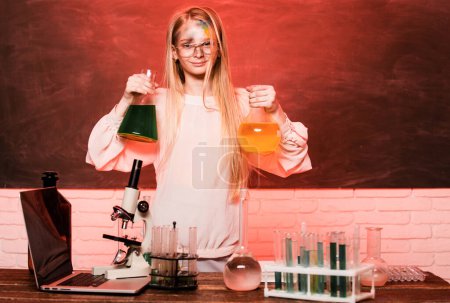 Foto de Ciencia y educación escolar. Una chica graciosa haciendo experimentos en el laboratorio. Explosión en el laboratorio. Científico infantil - Imagen libre de derechos